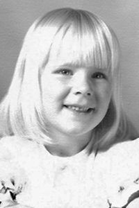 A black and white photograph of a young caucasian girl with blonde hair