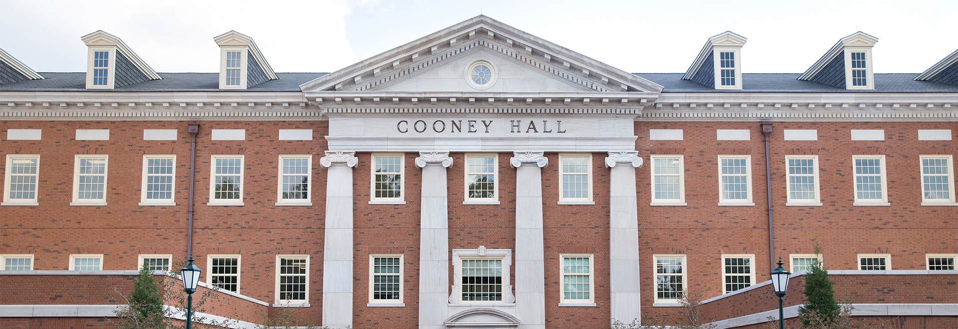 A photograph of the exterior of a red brick building labeled Cooney Hall
