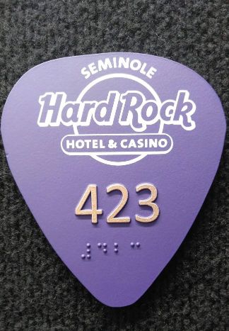 A room plaquard for the Hard Rock Hotel and Casino shaped like a large purple guitar pick.