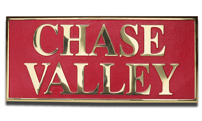 A square plaquard with the words "Chase Valley" in gold letters on a red background